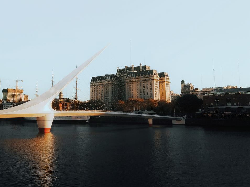 Puente de la Mujer, ponte branca de mastro inclinado, sobre a água de Puerto Madero ao entardecer