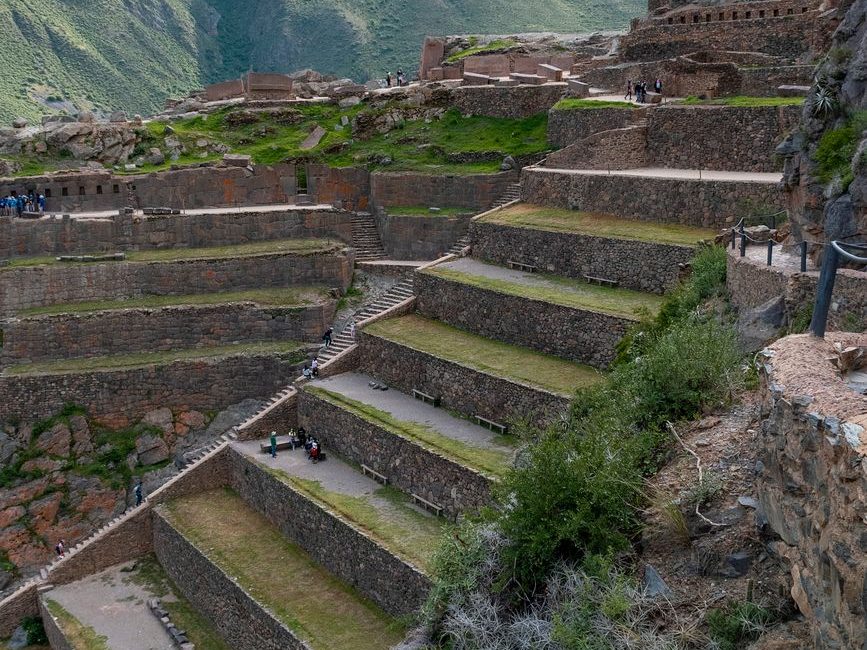 Terraços de pedra das ruínas de Ollantaytambo, com montanhas verdes ao fundo