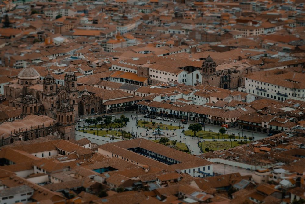 A Plaza de Armas de Cusco vista do alto, cercada por telhados vermelhos e igrejas
