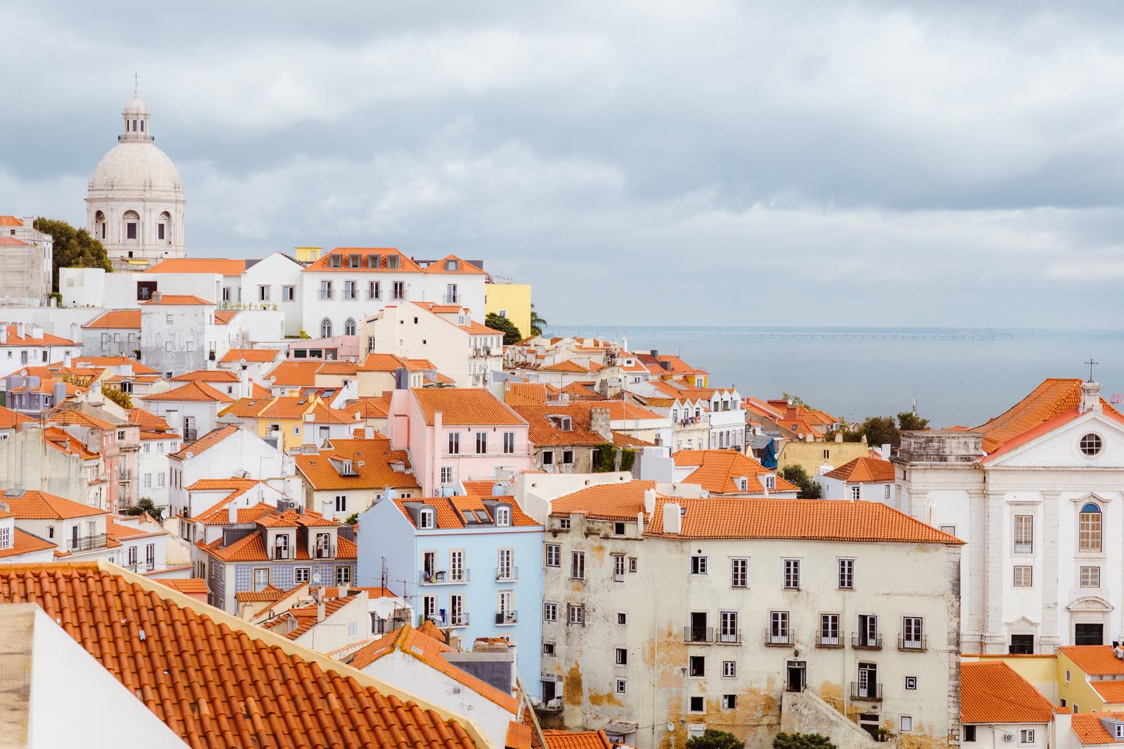 Telhados vermelhos da Alfama, em Lisboa, com o rio Tejo ao fundo