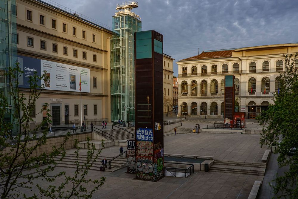 Praça do Museu Reina Sofía, com a torre de vidro dos elevadores e o edifício antigo ao fundo