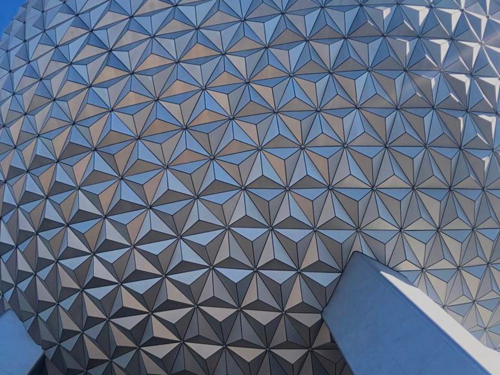 Detalhe da grande esfera prateada do EPCOT, com painéis triangulares refletindo o céu azul