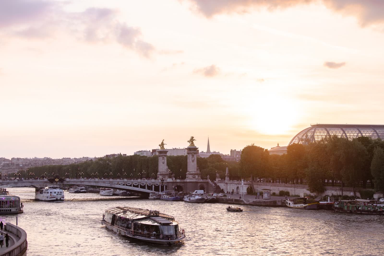 Rio Sena ao entardecer em Paris, com barcos e pontes