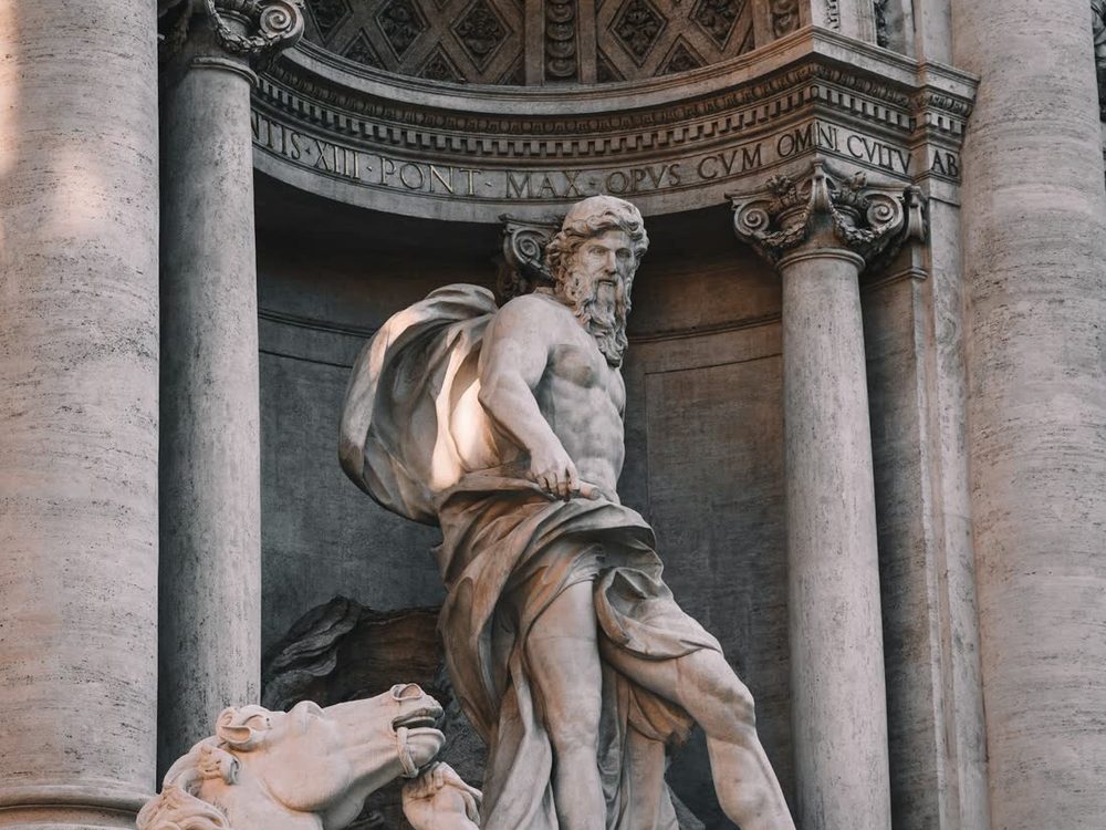 Estátua de Oceano no centro da Fontana di Trevi, entre colunas, com cavalos marinhos em primeiro plano