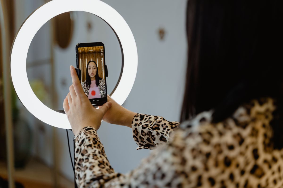 Criadora de conteúdo gravando um vídeo com o celular, ilustrando o perfil de parceiro do programa